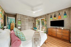 Guest-ready modern Airbnb bedroom in Houston with fresh linens and decorative swim fins, professional turnover by Aviva Cleaning Services.